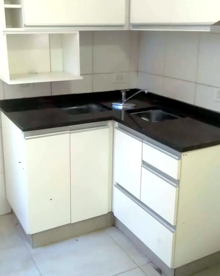 Cocina blanca con alacenas y mesada oscura